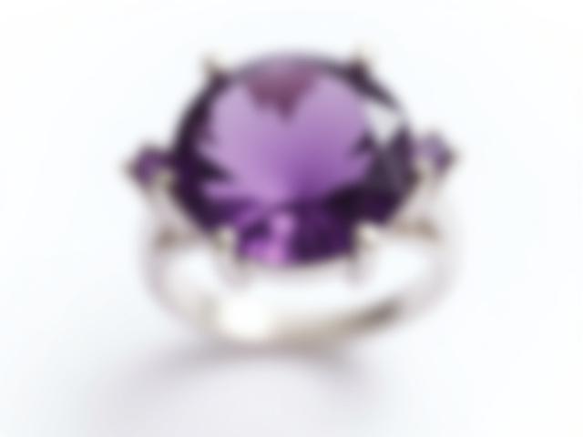 Anillo de plata con una gran amatista facetada que irradia tonos púrpura profundos.